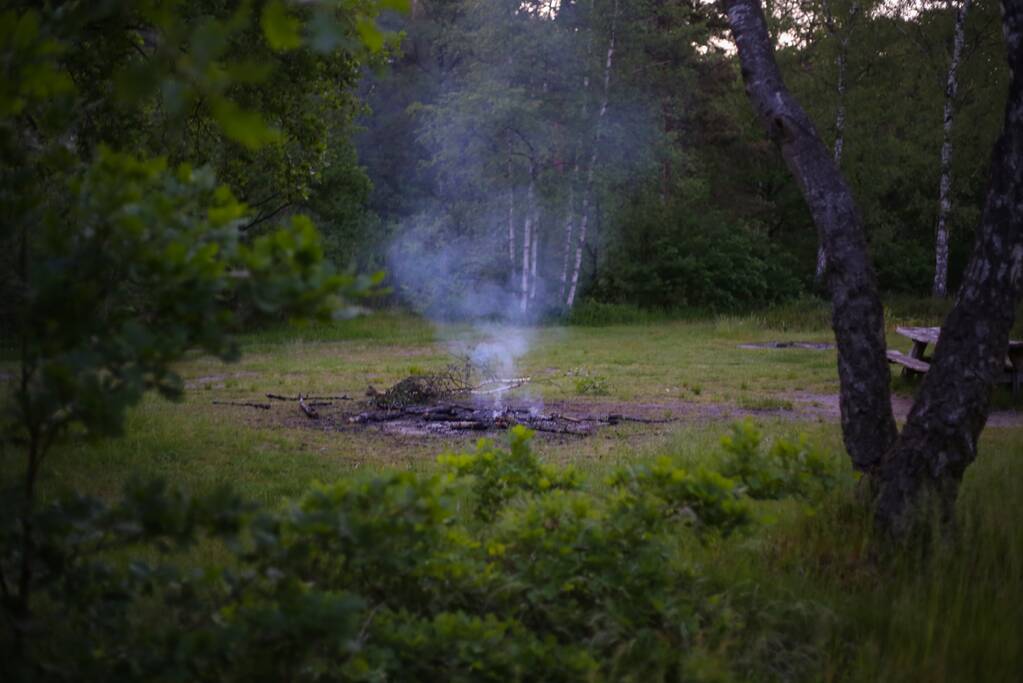 Stapel houten takken in brand in bosgebied De Bergjes