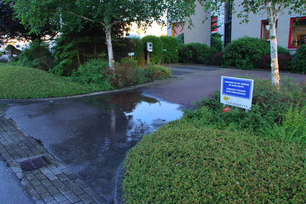 Waterlekkage op parkeerplaats van bedrijf