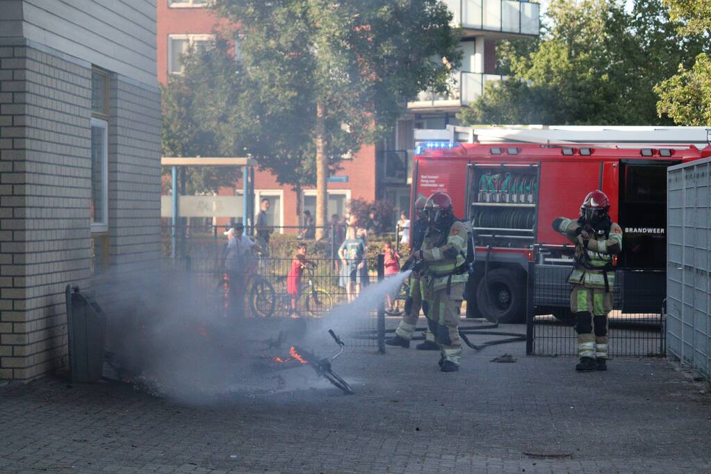 Brandweer blust brandende stapel fietsen