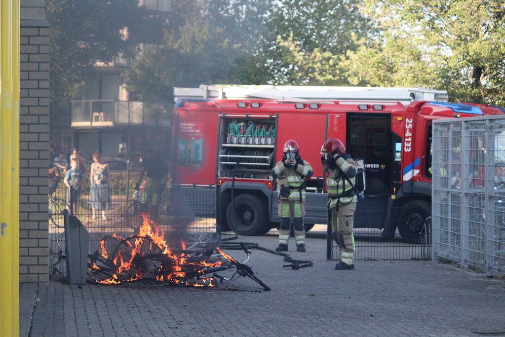 Brandweer blust brandende stapel fietsen