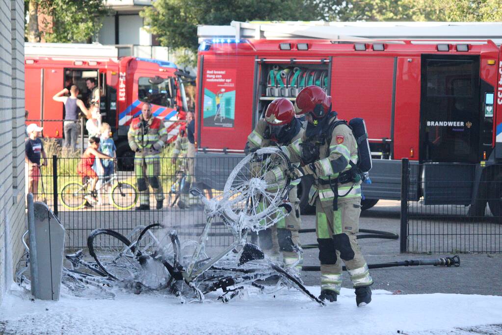 Brandweer blust brandende stapel fietsen