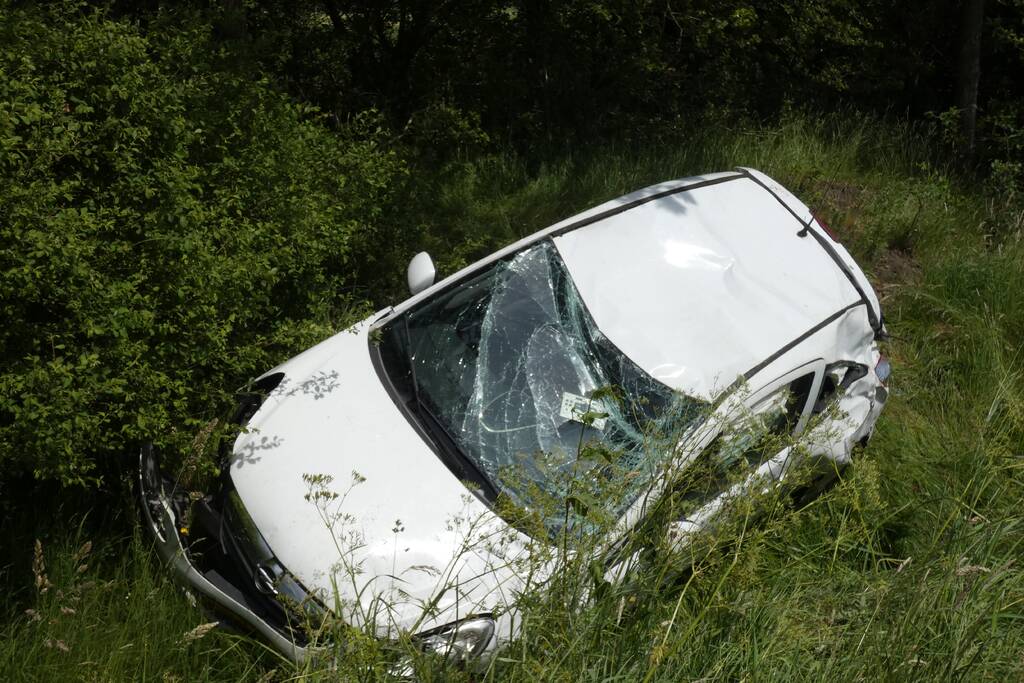 Automobilist rolt van talud af