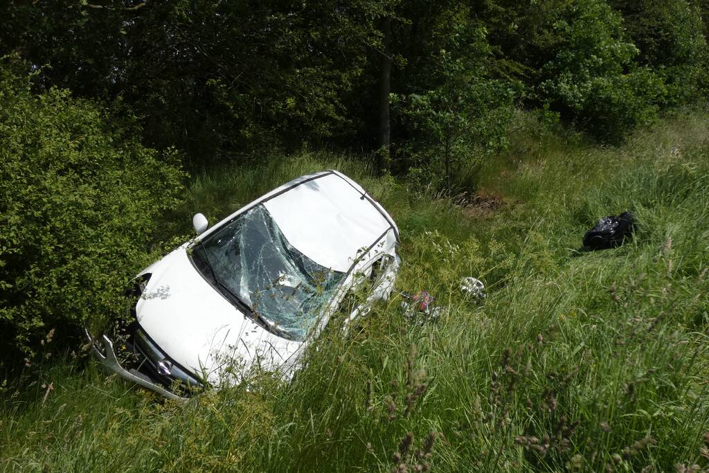 Automobilist rolt van talud af
