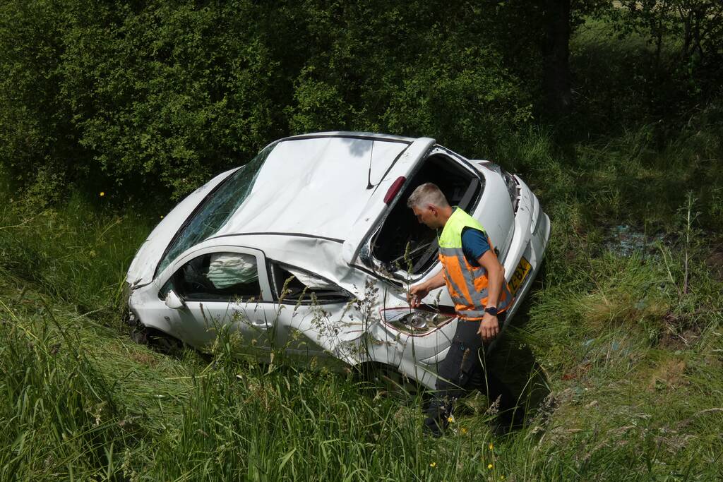 Automobilist rolt van talud af