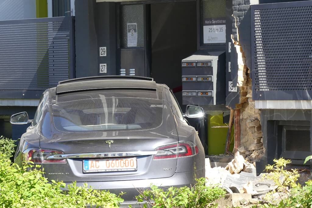 Auto botst tegen flatgebouw