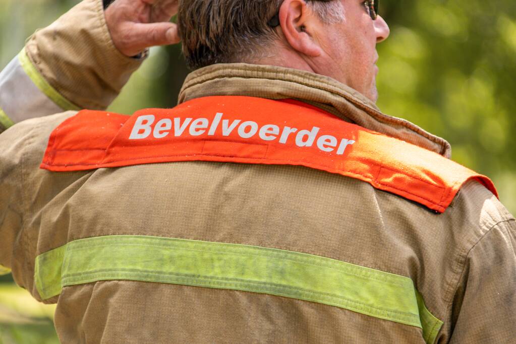 Puincontainer naast woning in brand