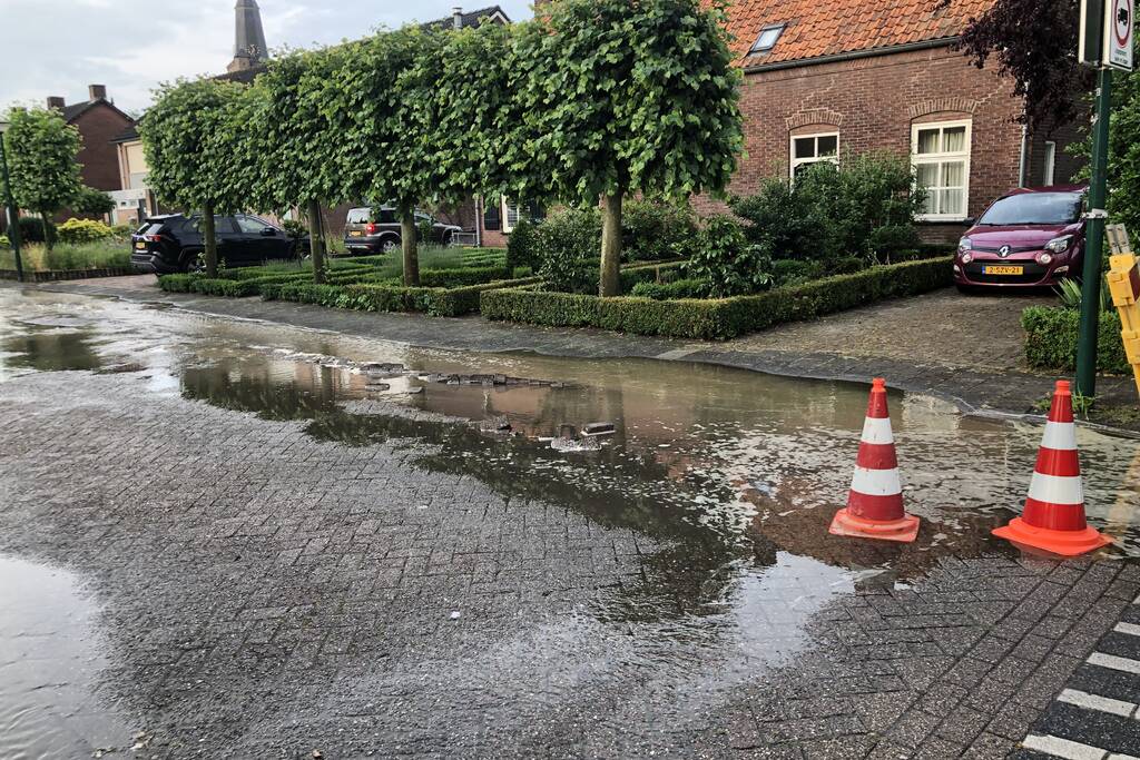 Straat onder water door gesprongen waterleiding