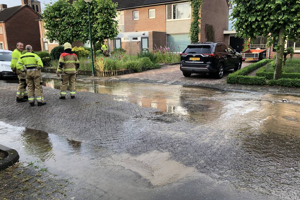 Straat onder water door gesprongen waterleiding