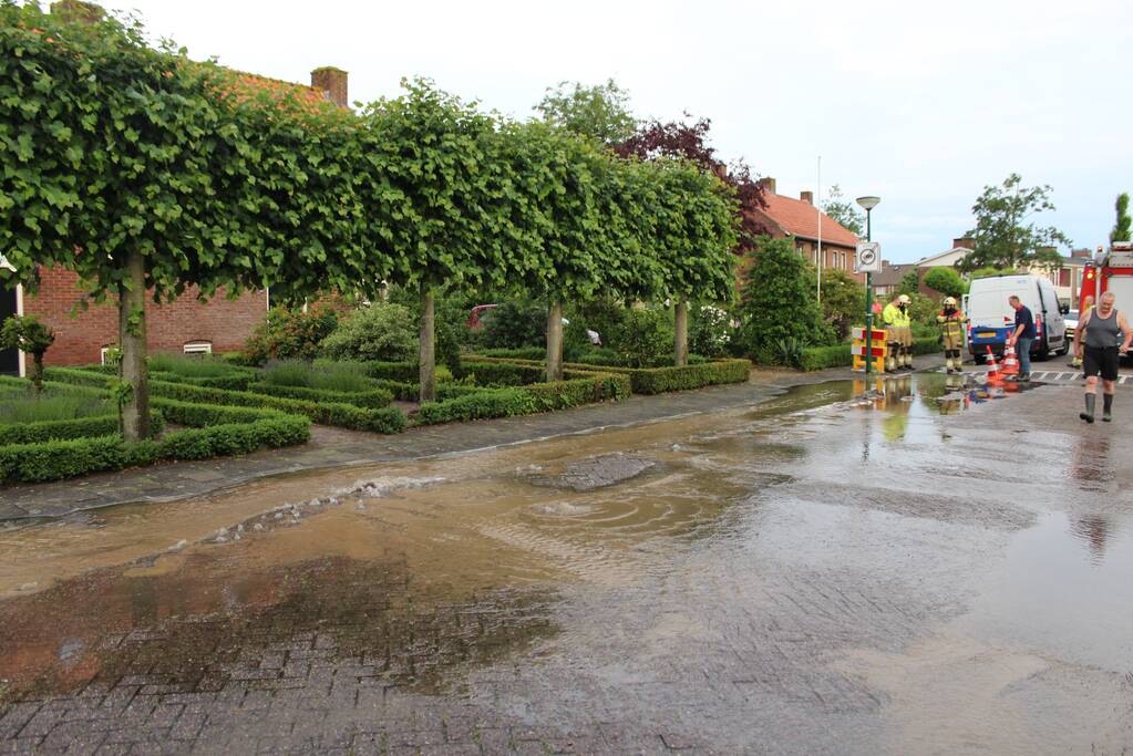 Straat onder water door gesprongen waterleiding