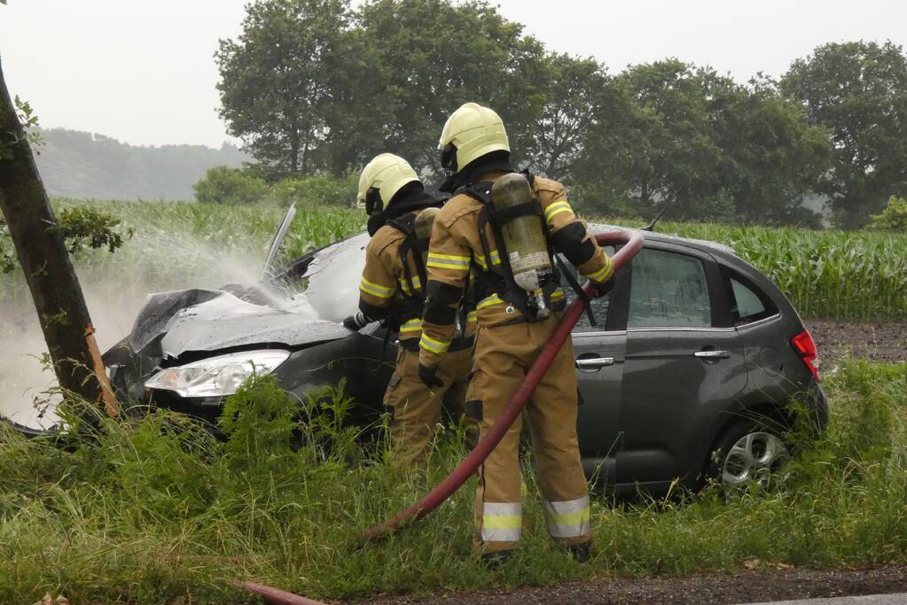 Auto vliegt in brand na botsing tegen boom