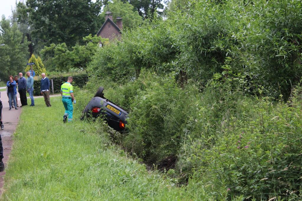 Auto op zijn kop in de sloot