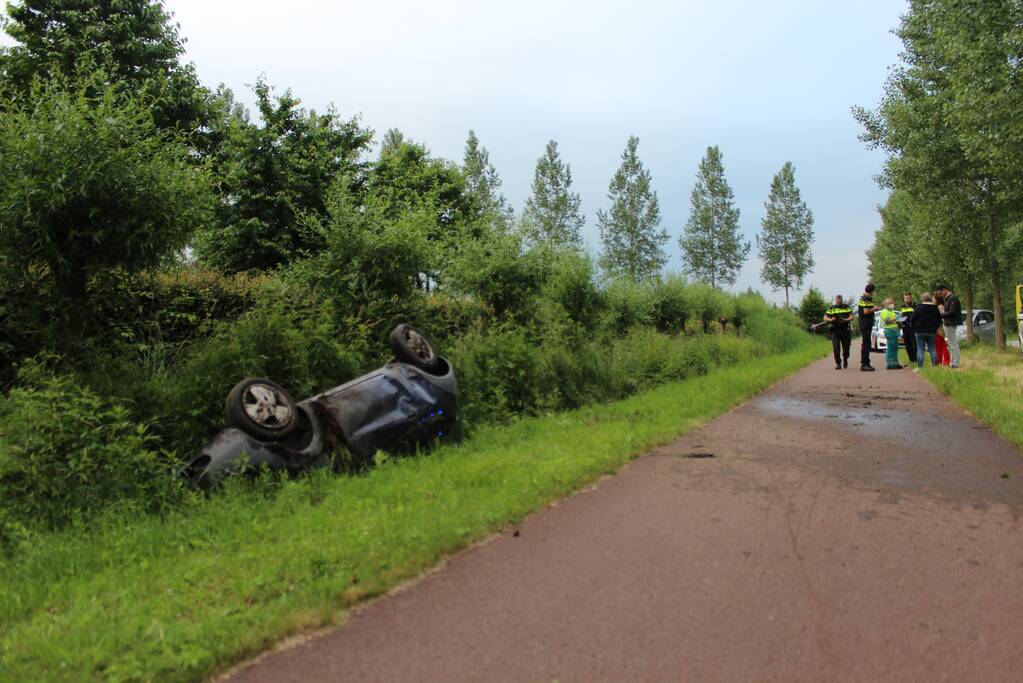 Auto op zijn kop in de sloot
