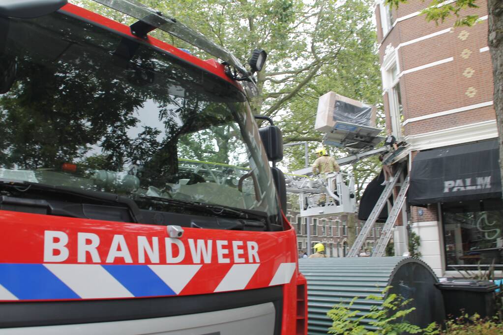 Man bekneld tussen gevel en verhuislift