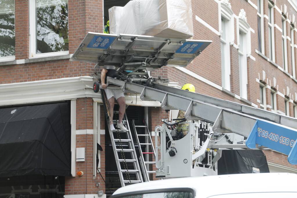 Man bekneld tussen gevel en verhuislift
