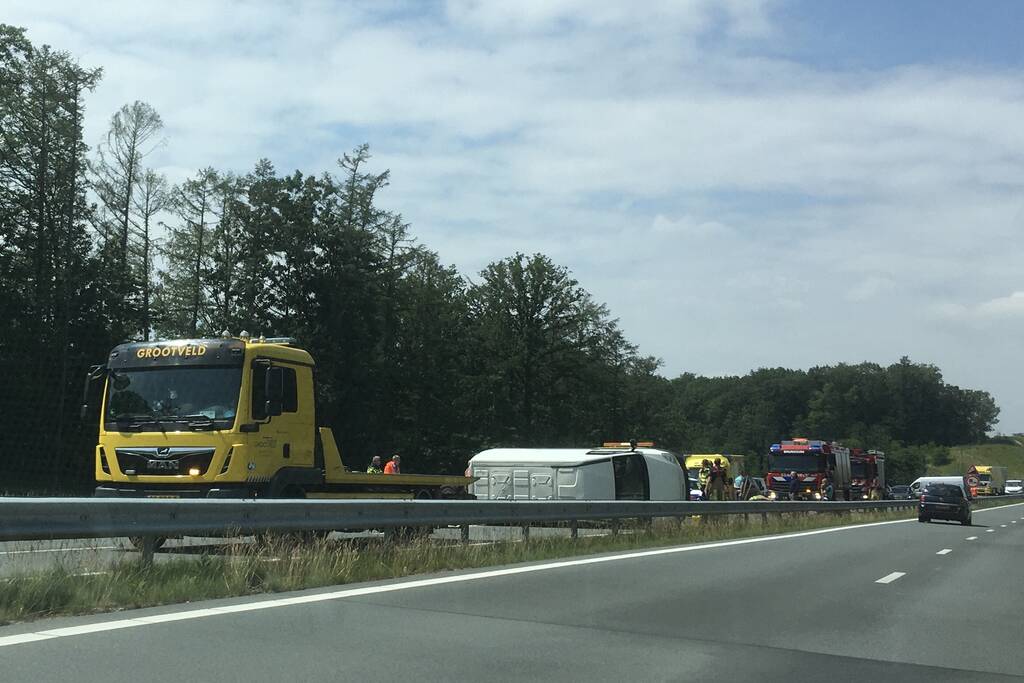 Bestelbus met aanhanger belandt op zijn kant