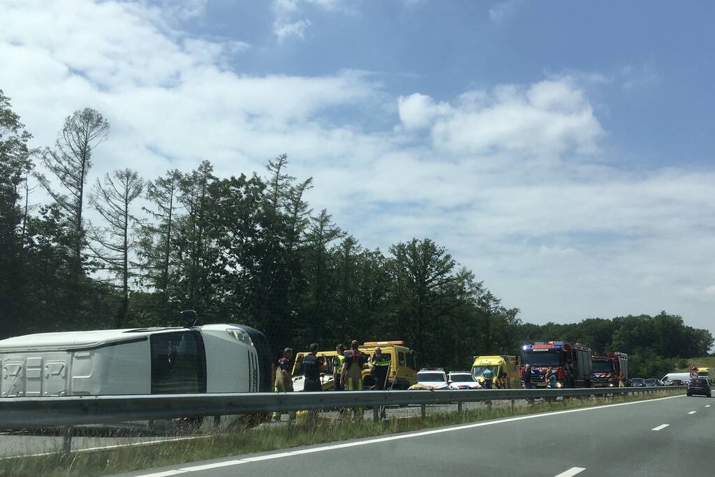 Bestelbus met aanhanger belandt op zijn kant