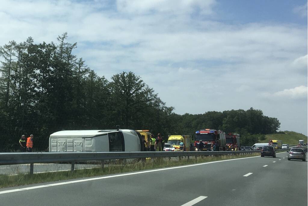 Bestelbus met aanhanger belandt op zijn kant