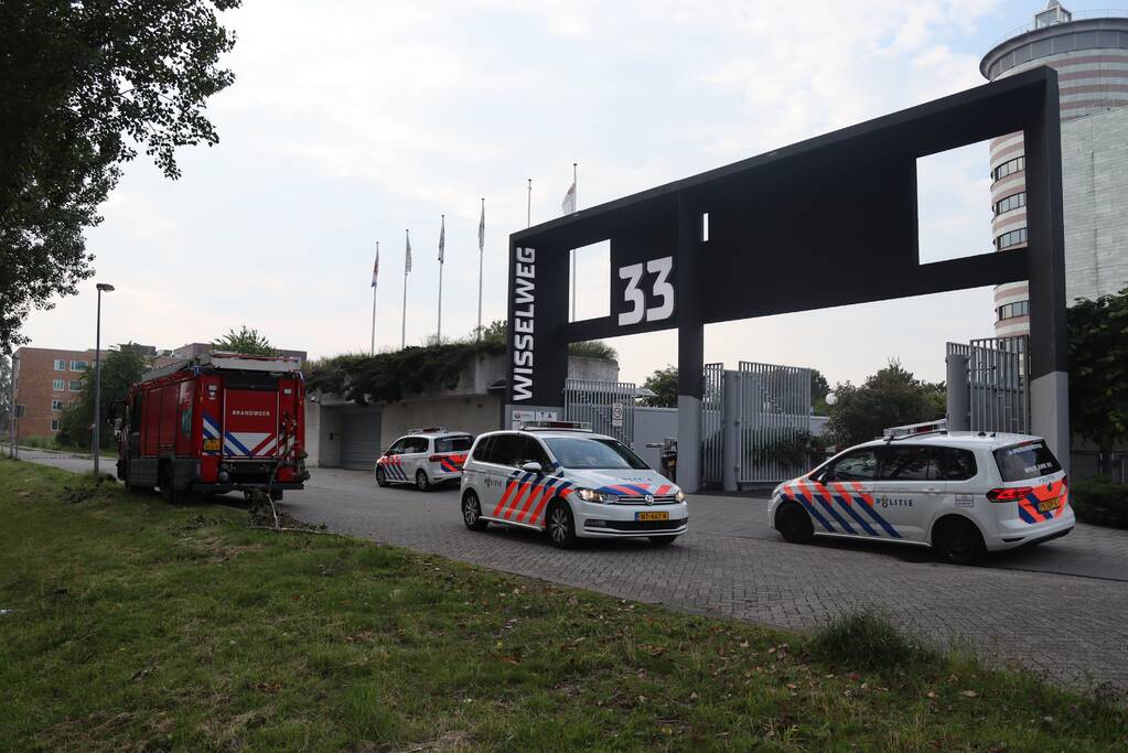 Man vast in hekwerk terrein kantoorgebouw