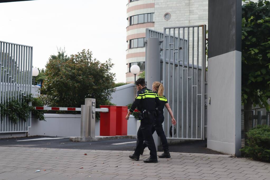 Man vast in hekwerk terrein kantoorgebouw