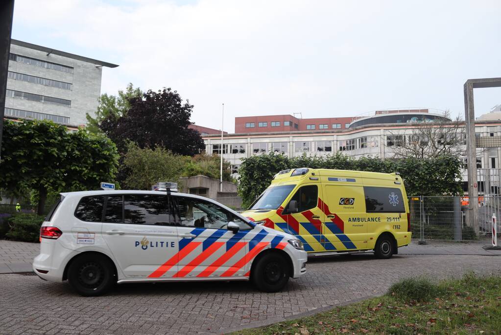 Man vast in hekwerk terrein kantoorgebouw