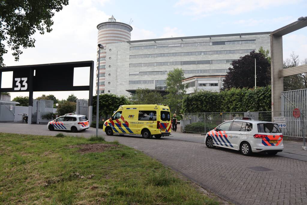 Man vast in hekwerk terrein kantoorgebouw