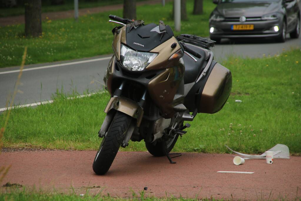 Motorfiets en auto botsen tegen elkaar