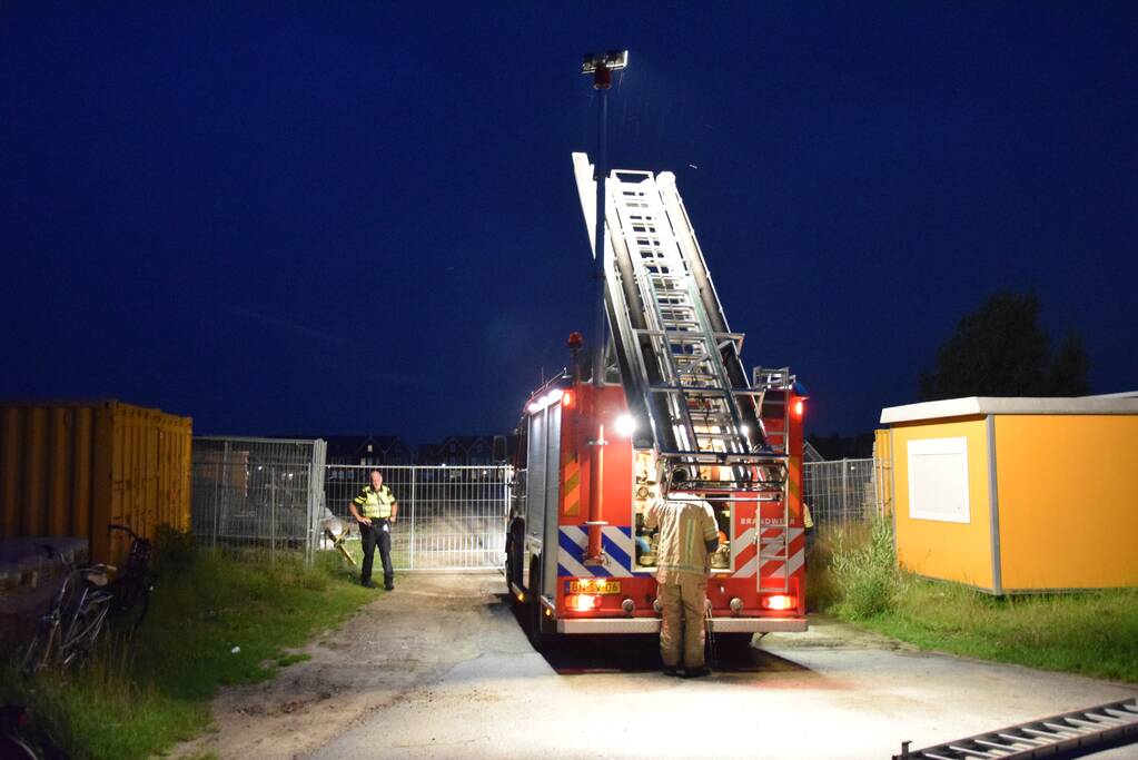 Brandstichting in stapel pallets op bouwterrein