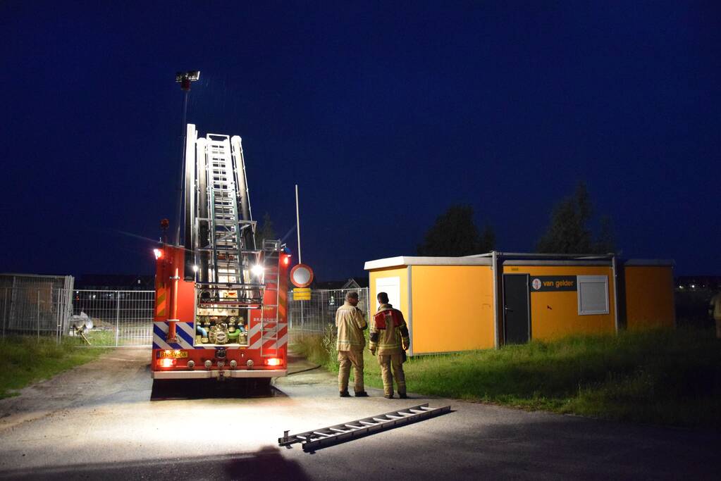 Brandstichting in stapel pallets op bouwterrein