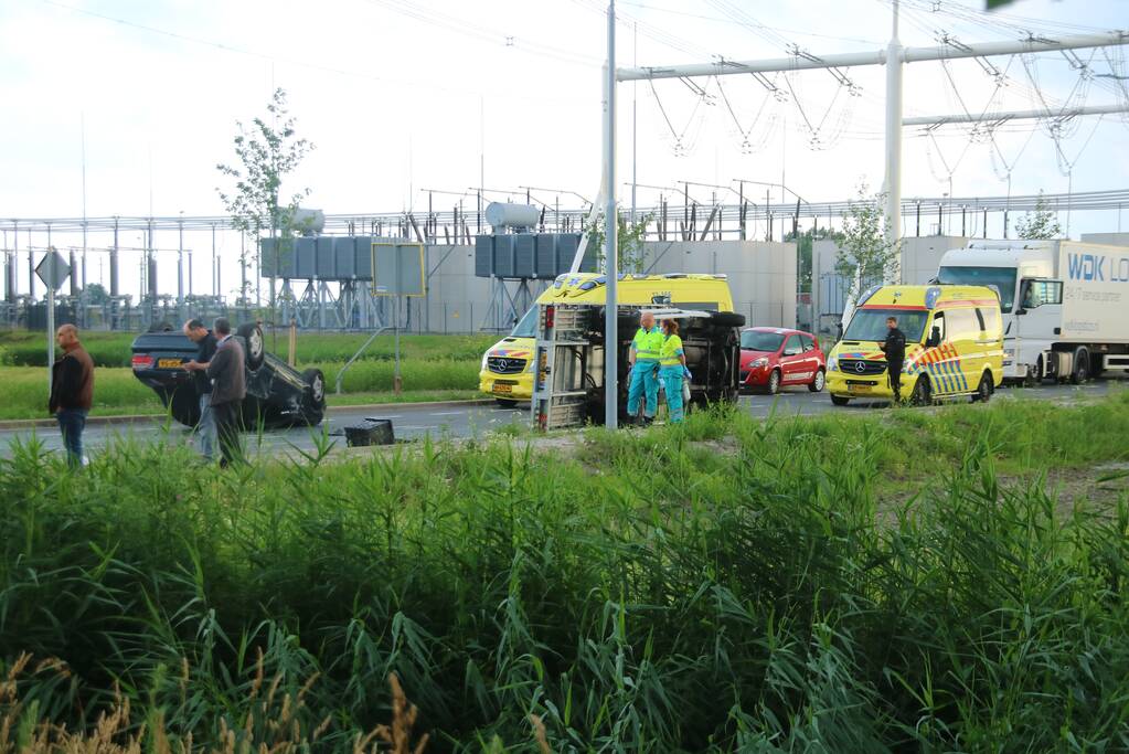 Autotransporter verliest auto en belandt op z'n kant na ongeval