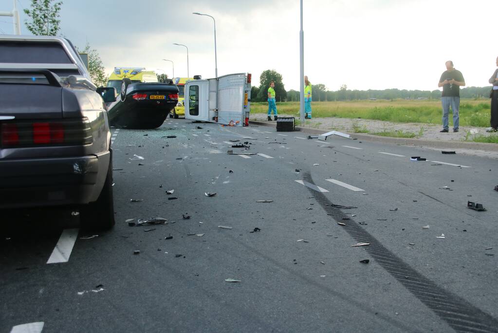 Autotransporter verliest auto en belandt op z'n kant na ongeval