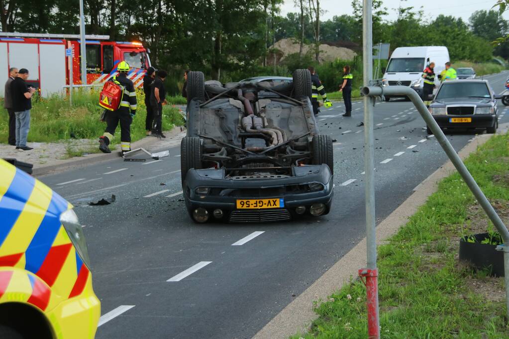 Autotransporter verliest auto en belandt op z'n kant na ongeval