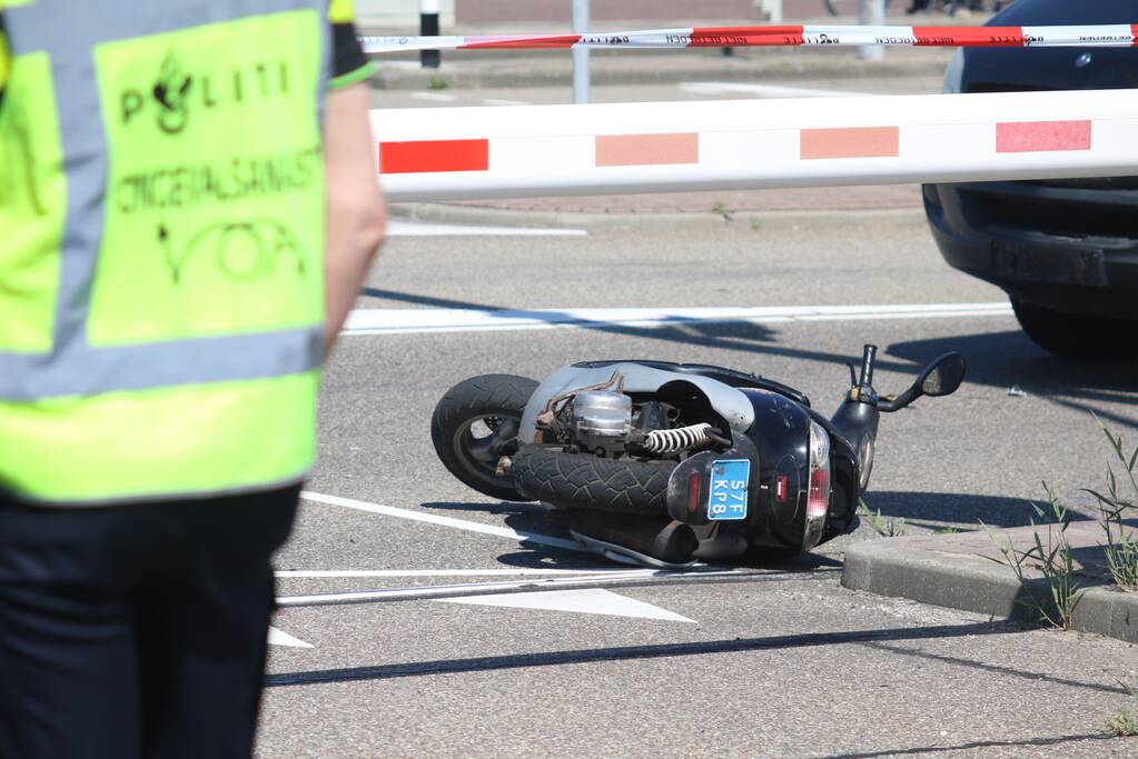 Auto botst op scooter voor ingang veerdienst
