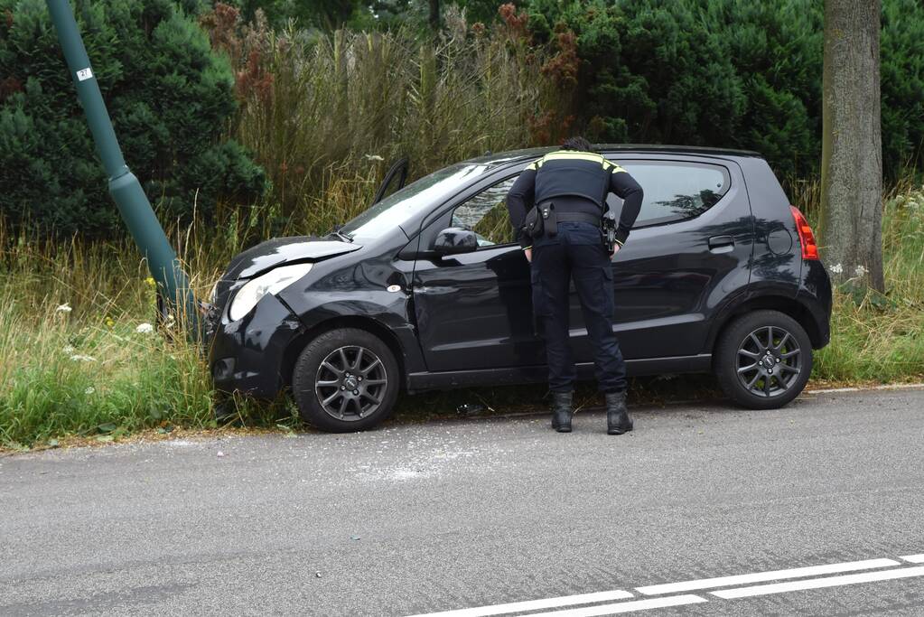 Automobilist parkeert auto tegen lantaarnpaal