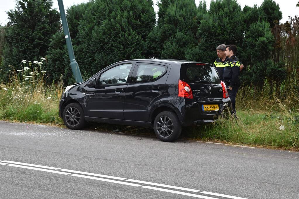 Automobilist parkeert auto tegen lantaarnpaal