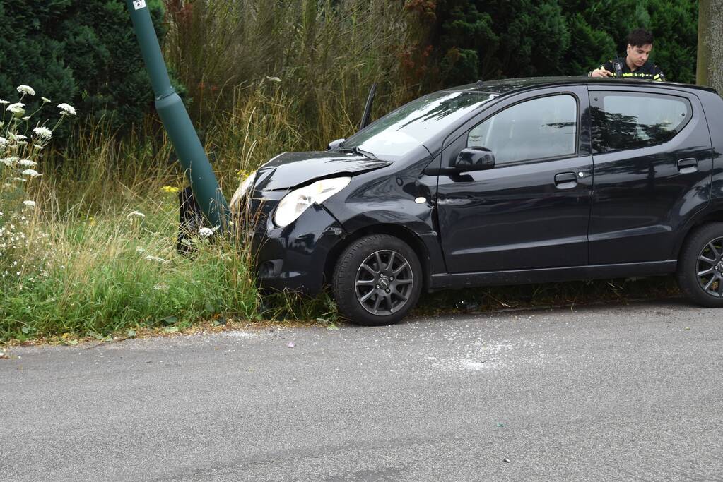 Automobilist parkeert auto tegen lantaarnpaal