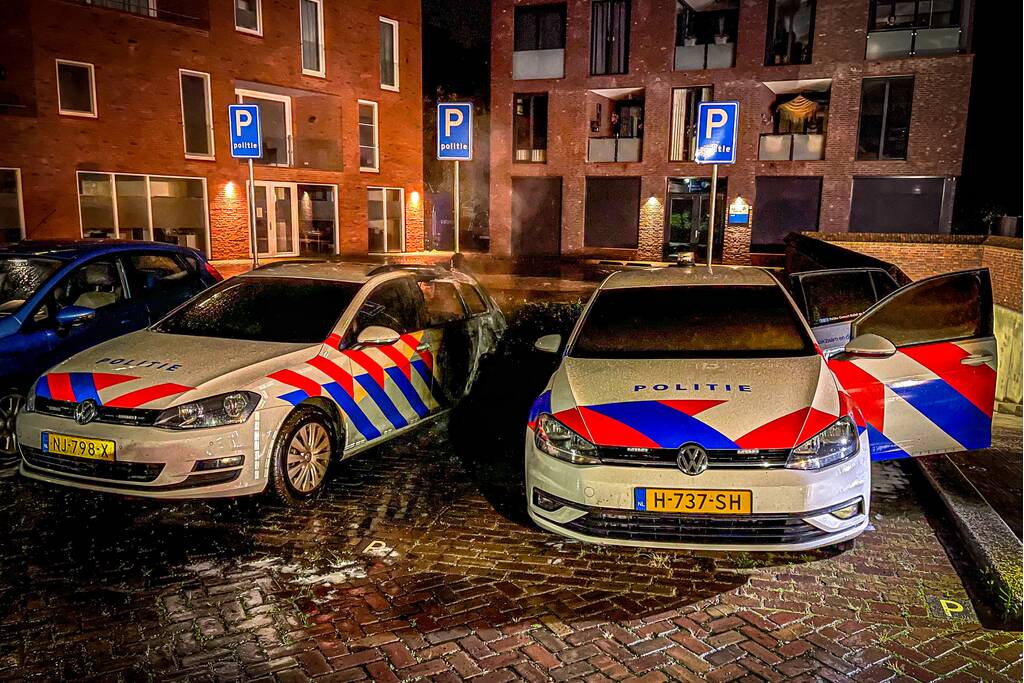 Twee politieauto's vliegen in brand