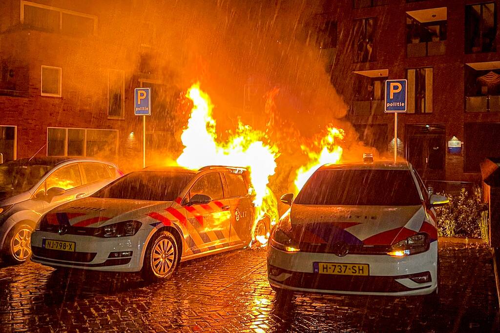 Twee politieauto's vliegen in brand