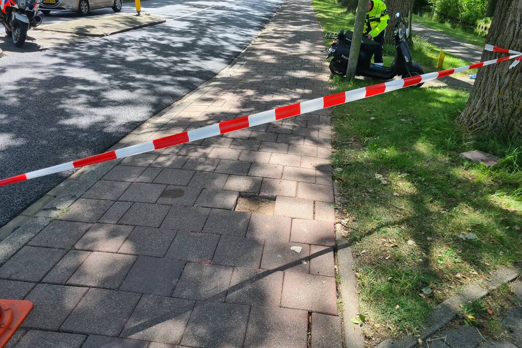 Scooterrijder onderuit door ontbrekende stoeptegel
