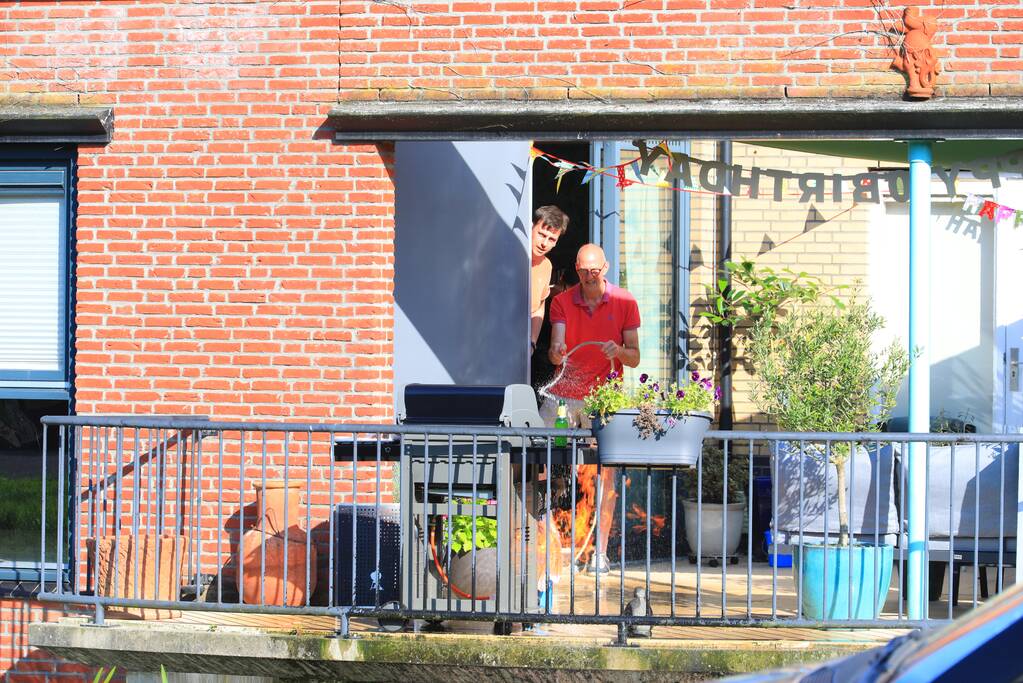 Barbecue met gasfles vat vlam