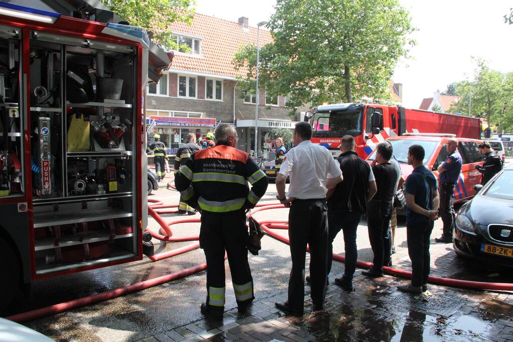 Zwarte rookwolken bij grote uitslaande woningbrand