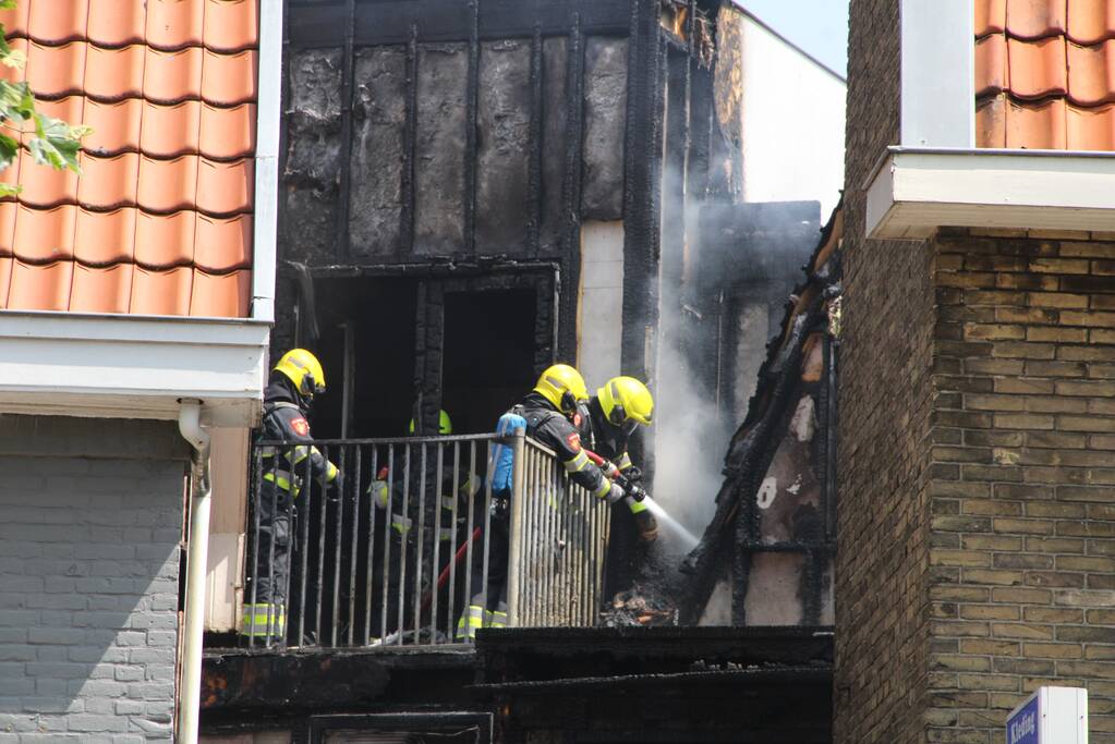 Zwarte rookwolken bij grote uitslaande woningbrand