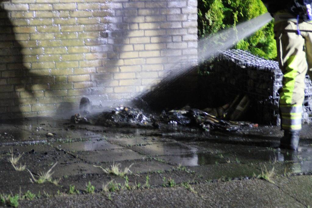 Schade aan muur door brandende papiercontainer