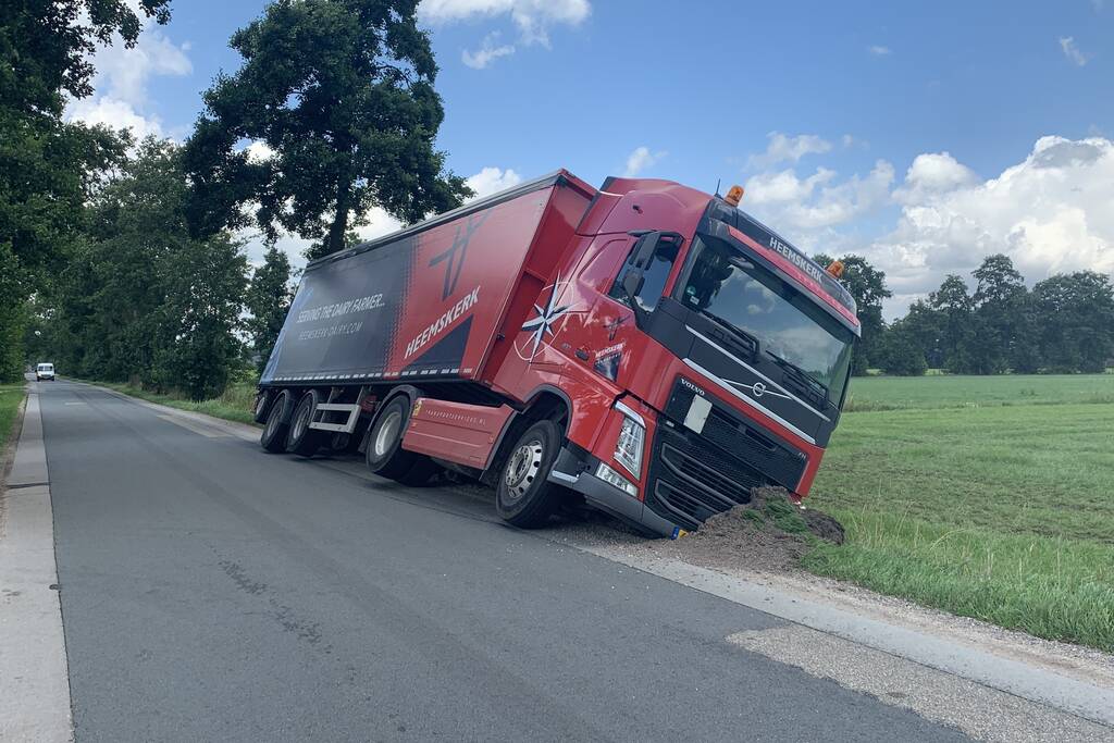 Vrachtwagen met oplegger komt vast te zitten in greppel