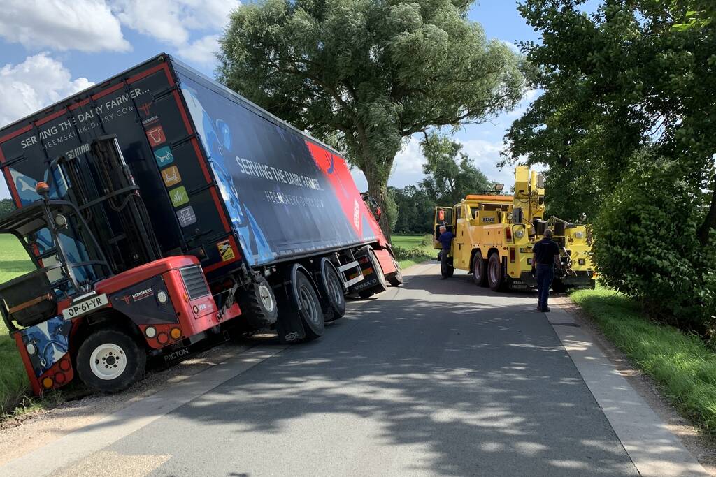 Vrachtwagen met oplegger komt vast te zitten in greppel