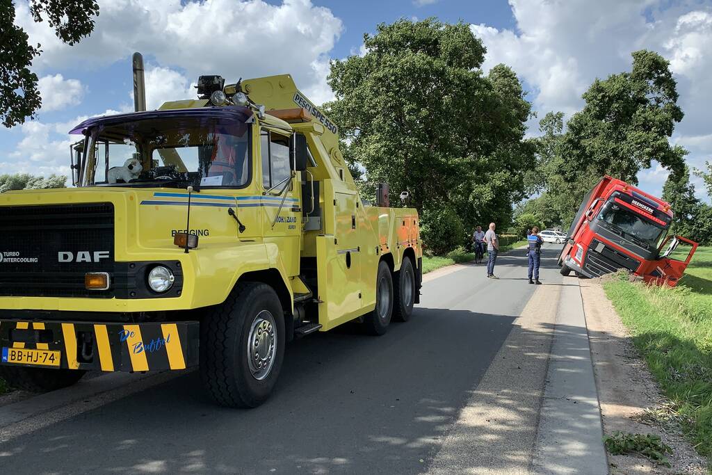 Vrachtwagen met oplegger komt vast te zitten in greppel