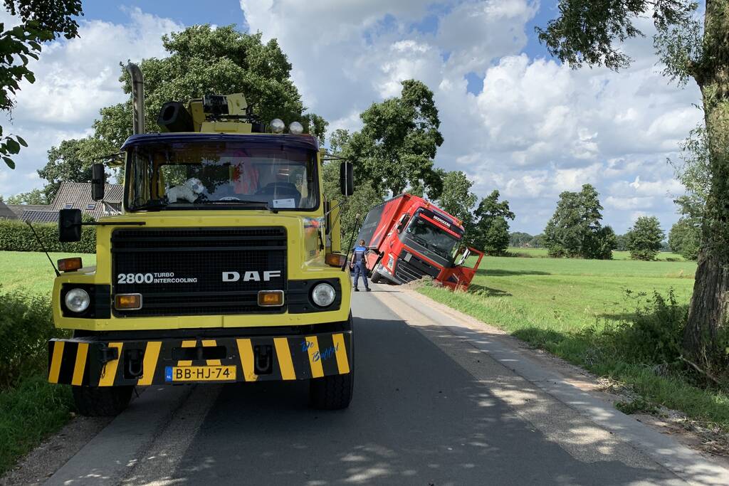 Vrachtwagen met oplegger komt vast te zitten in greppel