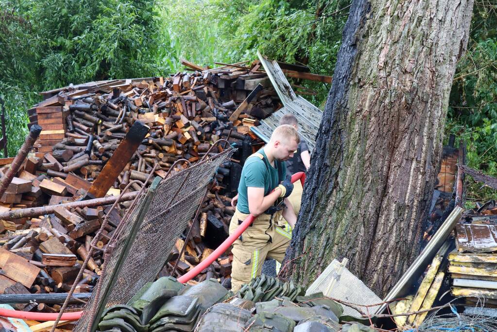 Brand in houtopslag slaat over naar schuur