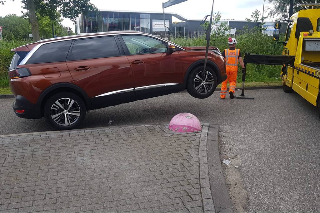 Auto belandt op betonnen sierbol