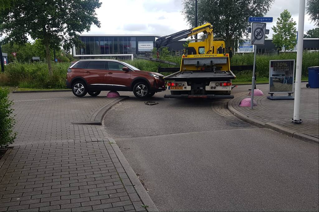 Auto belandt op betonnen sierbol