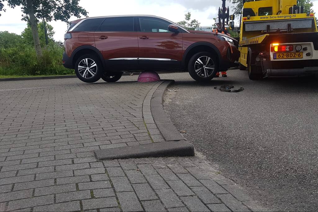 Auto belandt op betonnen sierbol